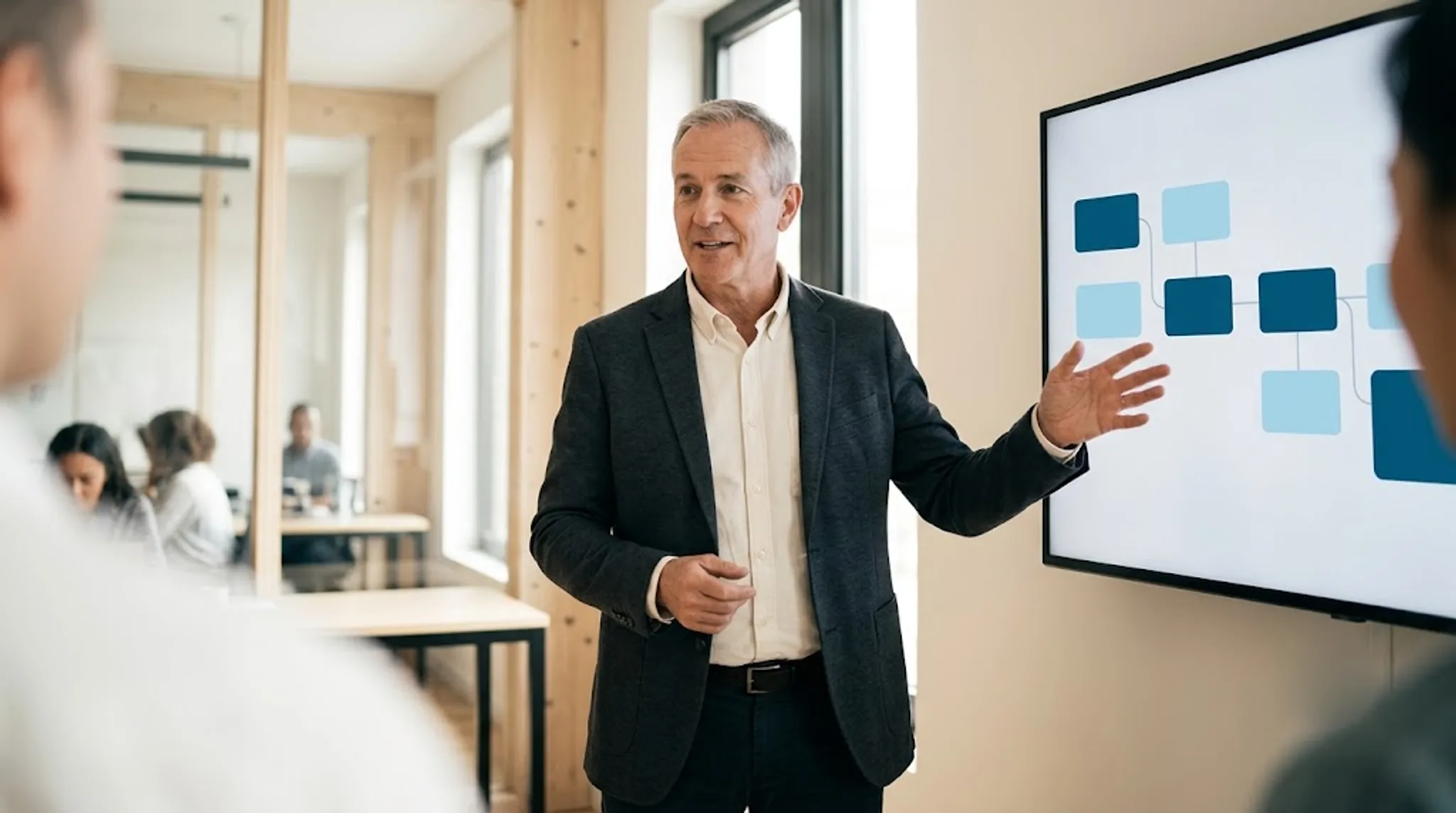 An experienced technology leader walking a team through a roadmap on a wall-mounted screen